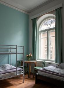 1 Schlafzimmer mit 2 Etagenbetten und einem Tisch mit einem Fenster in der Unterkunft Hostel Diana Park in Helsinki
