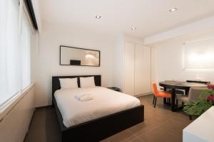 1 dormitorio con 1 cama y 1 mesa con silla en The Loft, en Bruselas