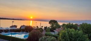 a view of a pool with the sunset in the background at Hotel Ristorante Al Fiore in Peschiera del Garda