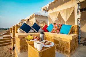 a couch with a bowl of fruit on a table at Desert Heritage Luxury Camp And Resort in Jaisalmer