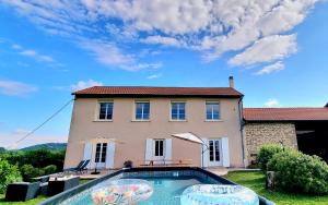 a house with a swimming pool in front of a house at La maison d’Emilie in Margès