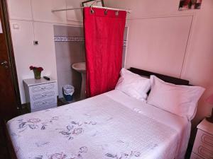 um quarto com uma cama com uma cortina vermelha em Pensão Prata em Lisboa