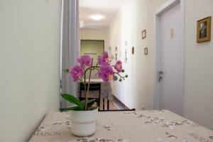 a vase with purple flowers sitting on a table at B&B Corso Italia in Pisa