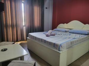 a bed in a room with a white bed frame at Hotel Europa in Lezhë