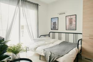 1 dormitorio con cama y ventana grande en Central & 1 min walk to the sea! "The Gallery" Apartment, Sliema, en Sliema