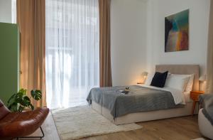 ein Schlafzimmer mit einem Bett und einem großen Fenster in der Unterkunft oompH Berlin 3BR Apt with Light Tones and Artwork in Berlin + 37 Fotos
