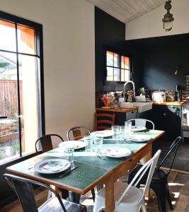 una mesa con platos y vasos en ella en una cocina en Maison Familiale Andernos les Bains, en Andernos-les-Bains