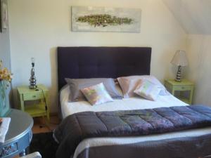 ein Schlafzimmer mit einem großen Bett mit zwei Nachttischen in der Unterkunft Les Mésanges in Estréelles