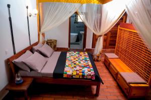 sypialnia z łóżkiem i ławką w pokoju w obiekcie Coccinelle appartements w mieście Bużumbura