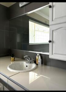 um lavatório branco numa cozinha com uma janela em Sleepover @194 em Rustenburg
