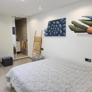 una camera da letto con un letto e un dipinto sul muro di Casa Salvia Bed and Breakfast a Icod de los Vinos