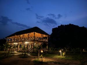 a wooden building with lights at night at Hill Stone View Hampi in Hampi