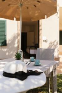 uma mesa com um chapéu e duas chávenas em Villa Chiara Porto Recanati em Porto Recanati