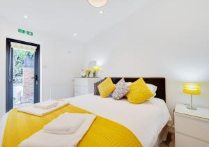 ein Schlafzimmer mit einem großen Bett mit gelben Kissen in der Unterkunft SeaBreeze Holiday Apartment in Swanage