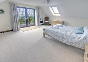 a bedroom with a bed and a large window at Holly Cottage in Seaton