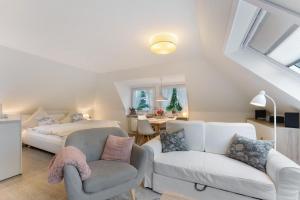 a bedroom with a bed and a couch and a chair at Appartement Skagen in Glücksburg