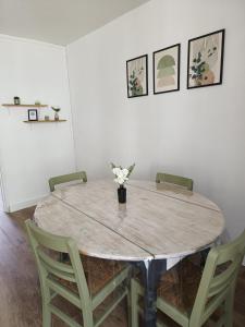 una mesa con sillas y un jarrón con flores. en Appartement Proche Centre Ville / 3 Chambres, en Perpiñán