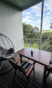 un portico con amaca, tavolo e altalena di Byron Bay Hinterlands Dreaming Woods Cabin One a Bangalow
