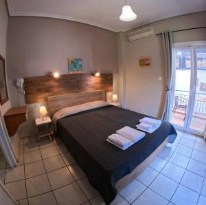 a bedroom with a bed with two towels on it at Garden House Katerina in Leptokarya