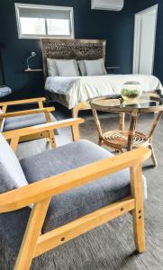 a living room with chairs and a table and a bed at Byron Bay Hinterlands Dreaming Woods Cabin Two in Bangalow