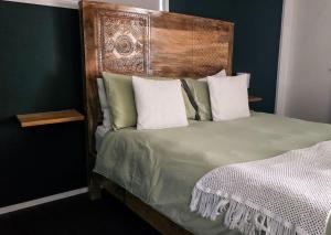 a bed with a wooden headboard in a bedroom at Byron Bay Hinterlands Dreaming Woods Cabin Three in Bangalow