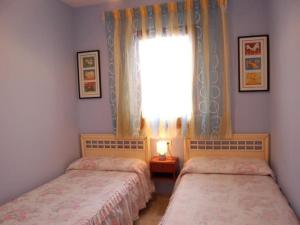two beds in a room with a window at Camins 2 in Riumar