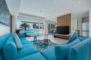 un soggiorno con divano blu e TV di WEG Elite Beachfront a Phuket