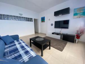 sala de estar con sofá azul y TV en Casa Gran Danés, en Santa Cruz de Tenerife