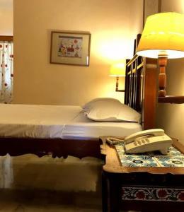 a bedroom with a bed and a phone on a table at K1 APARTMENTS in New Delhi