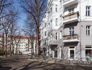 eine Straße in einer Stadt mit Gebäuden und Bäumen in der Unterkunft oompH Berlin 3BR Apt with Light Tones and Artwork in Berlin