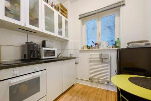 uma cozinha com armários brancos e uma mesa amarela em Wunderschöne 3 Zimmer Wohnung em Hamburgo