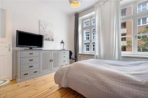 um quarto com uma cama e uma televisão de ecrã plano em Wunderschöne 3 Zimmer Wohnung em Hamburgo