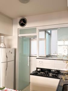 uma cozinha com um fogão e um frigorífico branco em Apê Curitiba I Familiar, tranquilo e sossegado em Belo Horizonte