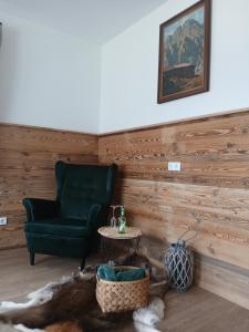 ein Wohnzimmer mit einem grünen Stuhl und einem Tisch in der Unterkunft Appartements Kumming in Rauris