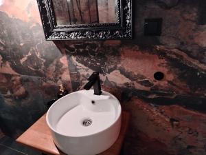uma casa de banho com um lavatório branco e um espelho. em Maximilian apartman em Smederevo