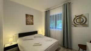 1 dormitorio con 1 cama con sábanas blancas y ventana en Busteni Mountain View Suites by the River - EV Plug en Buşteni