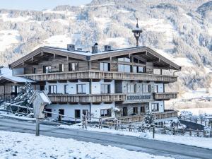 ヒパッハにあるFarmhouse in Schwendau with Ski Storageの雪山の大木造建築