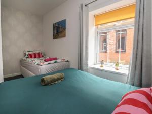a bedroom with a blue bed and a window at The Old Police House in Withernsea +27 photos