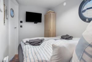 een slaapkamer met een bed en een flatscreen-tv bij Hausboot Seeadler Stralsund in Stralsund