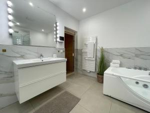 La salle de bains blanche est pourvue d'un lavabo, d'une baignoire et d'un miroir. dans l'établissement Haus-Nordseebrandung-FeWo-8, à Cuxhaven