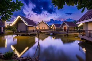 a row of houses on a river at night at Araliya Beach Resort & Spa Unawatuna- Where you meet the sea all year in Unawatuna