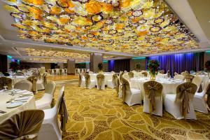 a banquet hall with white tables and chairs and a large ceiling at Araliya Beach Resort & Spa Unawatuna in Unawatuna
