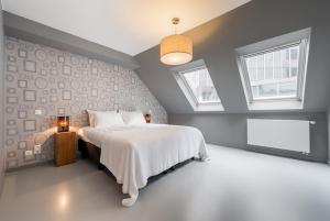 een slaapkamer met een wit bed en 2 ramen bij Smartflats Design - Postiers in Brussel