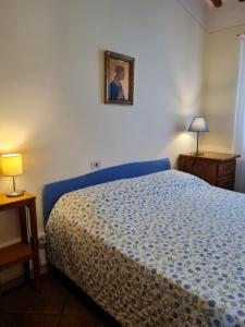 Schlafzimmer mit einem Bett mit blauer Tagesdecke in der Unterkunft Orto di Cornelio in Cincelli