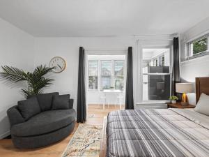 a bedroom with a bed and a chair and a window at Shadyside, Central !5 Stylish and Bright Studio With Free Parking in Pittsburgh
