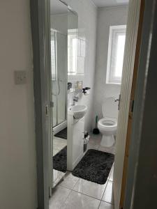 uma casa de banho com um lavatório e um WC em Dane Guest House Free Parking Fast WiFi Modern Living em Burnley