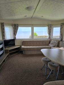 a living room with a couch and a table at Castaways Holiday Park in Bacton
