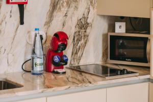a kitchen counter with a bottle of water and a red blender at Oporto Maison Palace in Porto +111 photos