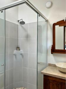 a glass shower in a bathroom with a sink at Extraordinaria Casa en el Centro Histórico Villa de Leyva - Sol de Iguaque in Villa de Leyva