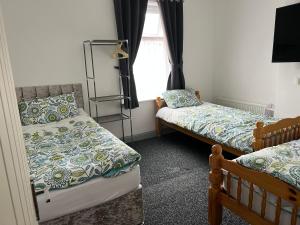 a bedroom with two beds and a window at Dane Guest House Free Parking Fast WiFi Modern Living in Burnley